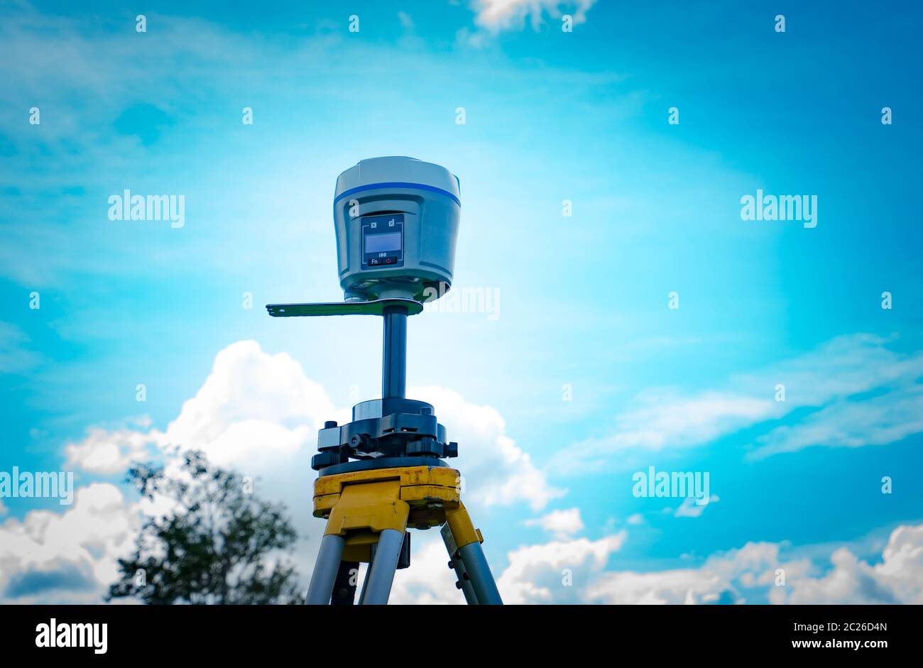GPS surveying instrument on blue sky background Stock Photo