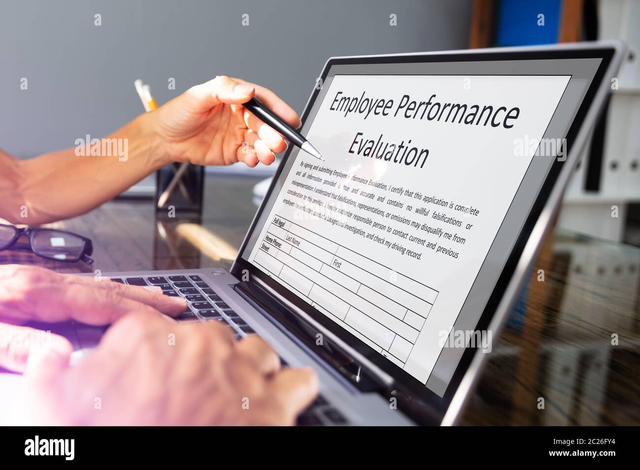 Close-up Of Two Businesspeople Filling Employee Performance Evaluation Form  On Laptop Over Office Desk Stock Photo - Alamy