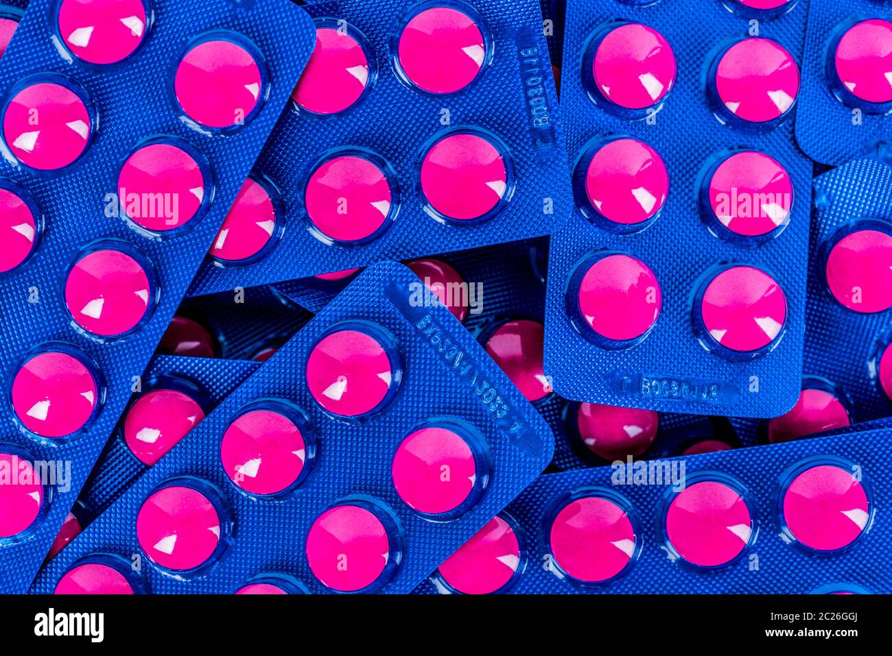 Full frame of pile of ibuprofen in pink tablet pills pack in blue