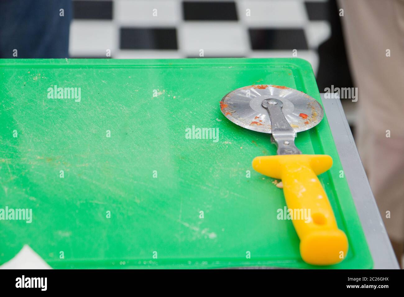 Pizza cutter on green desk. Stock Photo