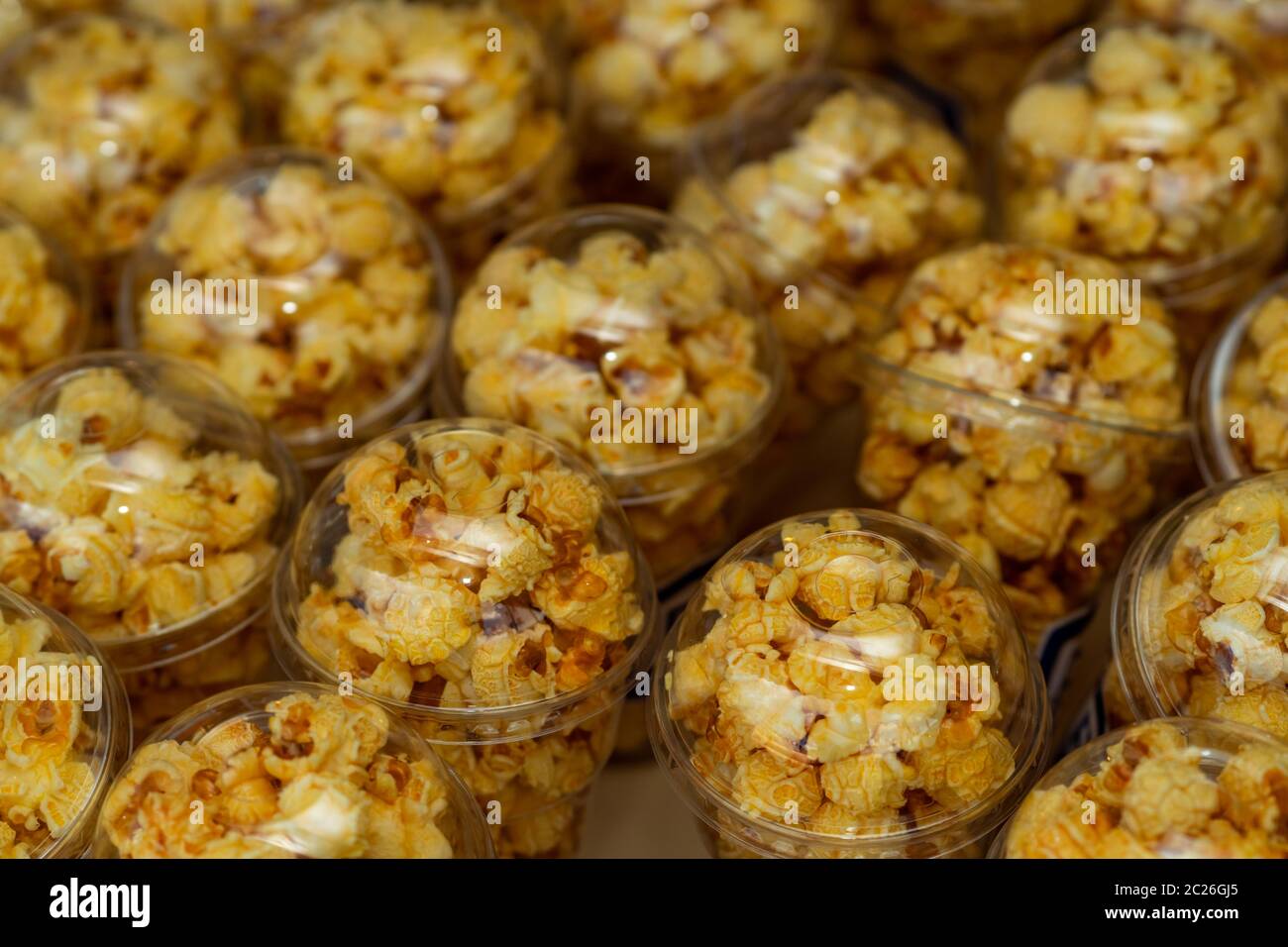 Popcorn in a plastic cup is beautifully placed. Unhealthy food or snack