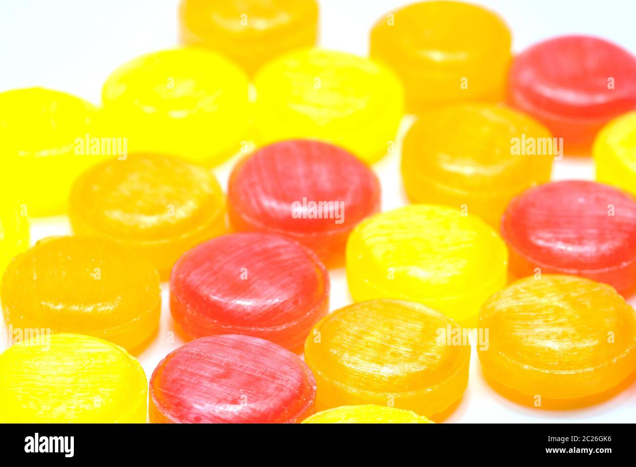 Medical lozenges for relief cough, sore throat and throat irritation isolated on white background. Cough and colds drop. Colorful cough pastille. Red, orange, and yellow round candy or sweets. Stock Photo