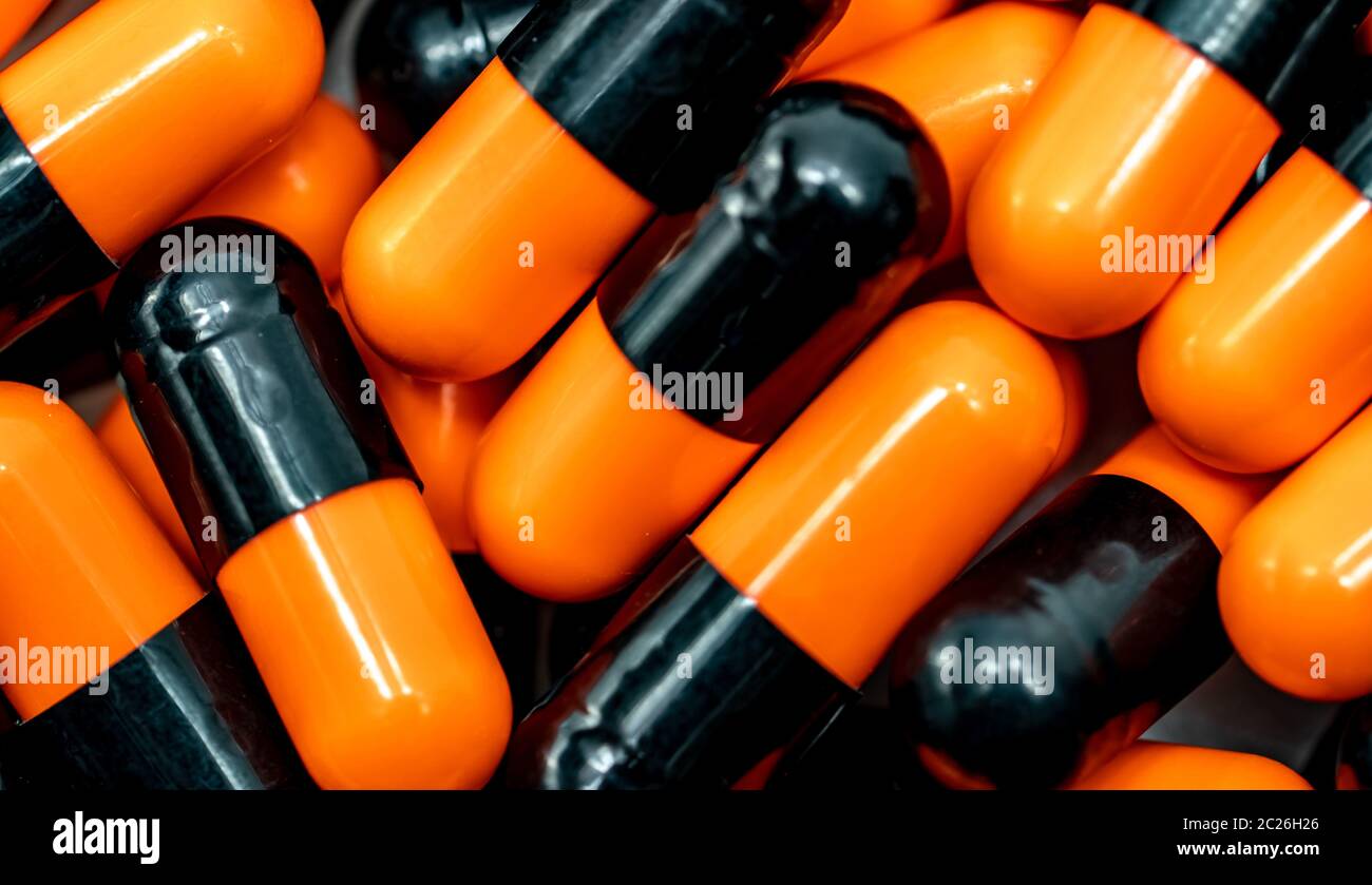 Top view of orange, black antibiotic capsule pills. Pharmaceutical