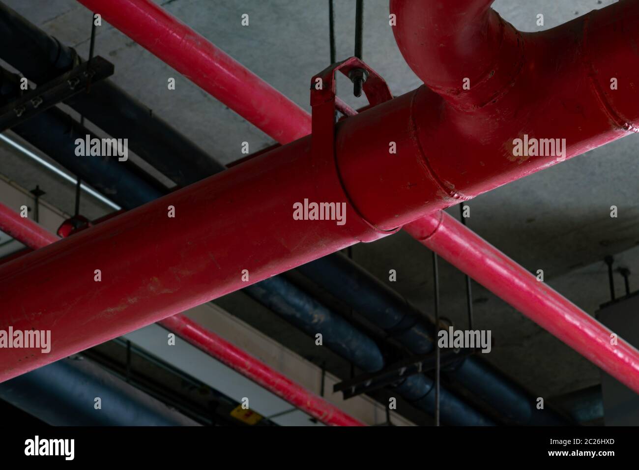 Fire sprinkler system with red pipes hanging from ceiling inside