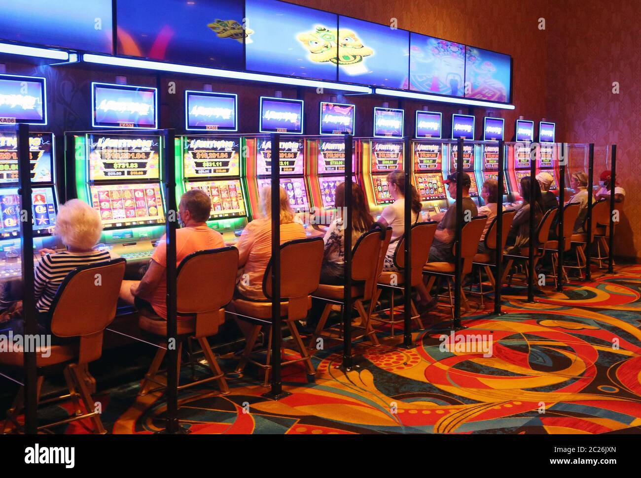 Maryland Heights, United States. 16th June, 2020. Guests play machines with plexiglass dividers between each other at the Hollywood Hotel and Casino, on day one of reopening to the public in Maryland Heights, Missouri on Tuesday, June 16, 2020. After being closed for nearly three months because of COVID-19 concerns, guests will now be asked questions about their health before being admitted to the casino floor, plexi-glass separators are installed between machines and guests are encouraged to wear masks while using the machines. Photo by Bill Greenblatt/UPI Credit: UPI/Alamy Live News Stock Photo