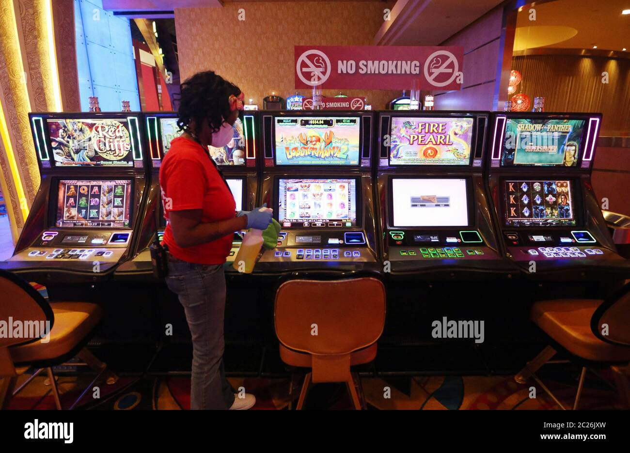 Maryland Heights, United States. 16th June, 2020. A worker at the Hollywood Hotel and Casino, wipes down machines after the casino has reopened to the public in Maryland Heights, Missouri on Tuesday, June 16, 2020. After being closed for nearly three months because of COVID-19 concerns, guests will now be asked questions about their health before being admitted to the casino floor, plexi-glass separators are installed between machines and guests are encouraged to wear masks while using the machines. Photo by Bill Greenblatt/UPI Credit: UPI/Alamy Live News Stock Photo
