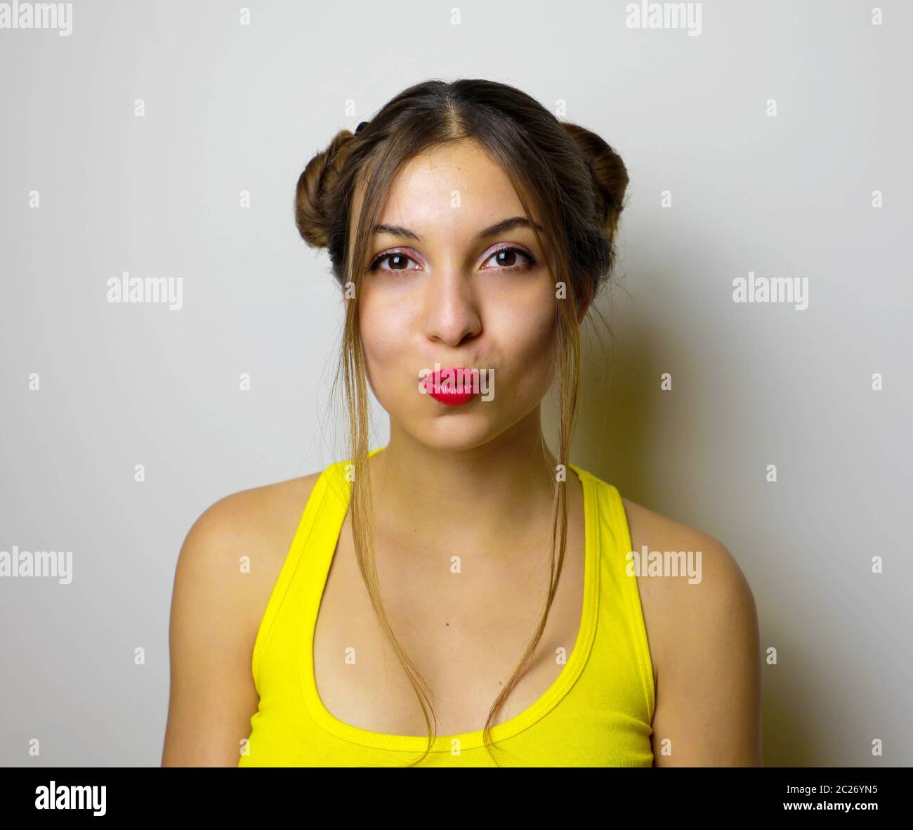 Beautiful girl with two hair chignon send kiss to the camera Stock Photo