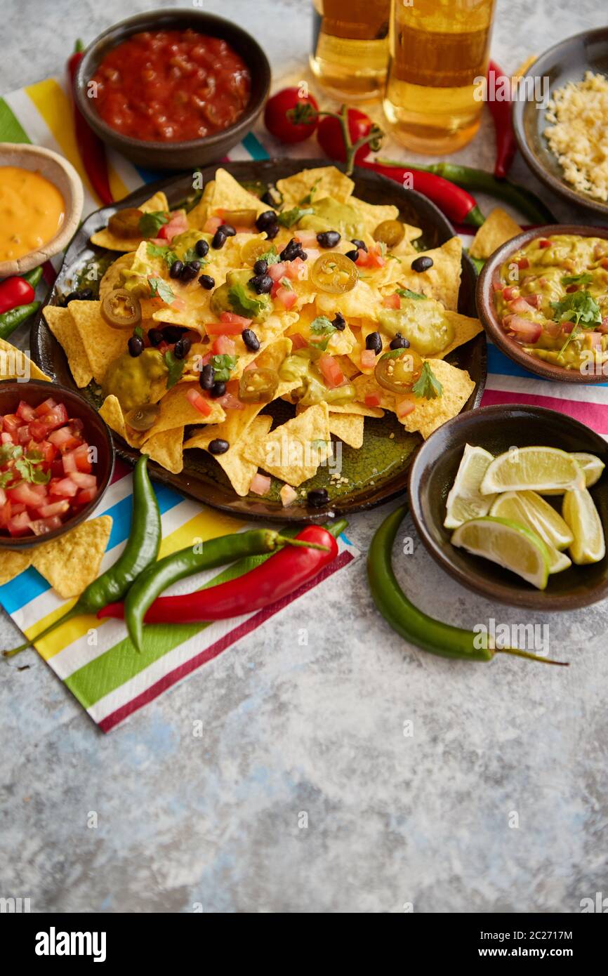 Mexican nachos tortilla chips with black bean, jalapeno, guacamole Stock Photo Alamy