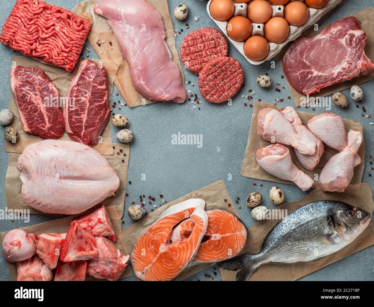 Carnivore diet concept. Raw ingredients for zero carb diet - meat, poultry, fish, seafood, eggs, beef bones for bone broth and copy space in center on Stock Photo