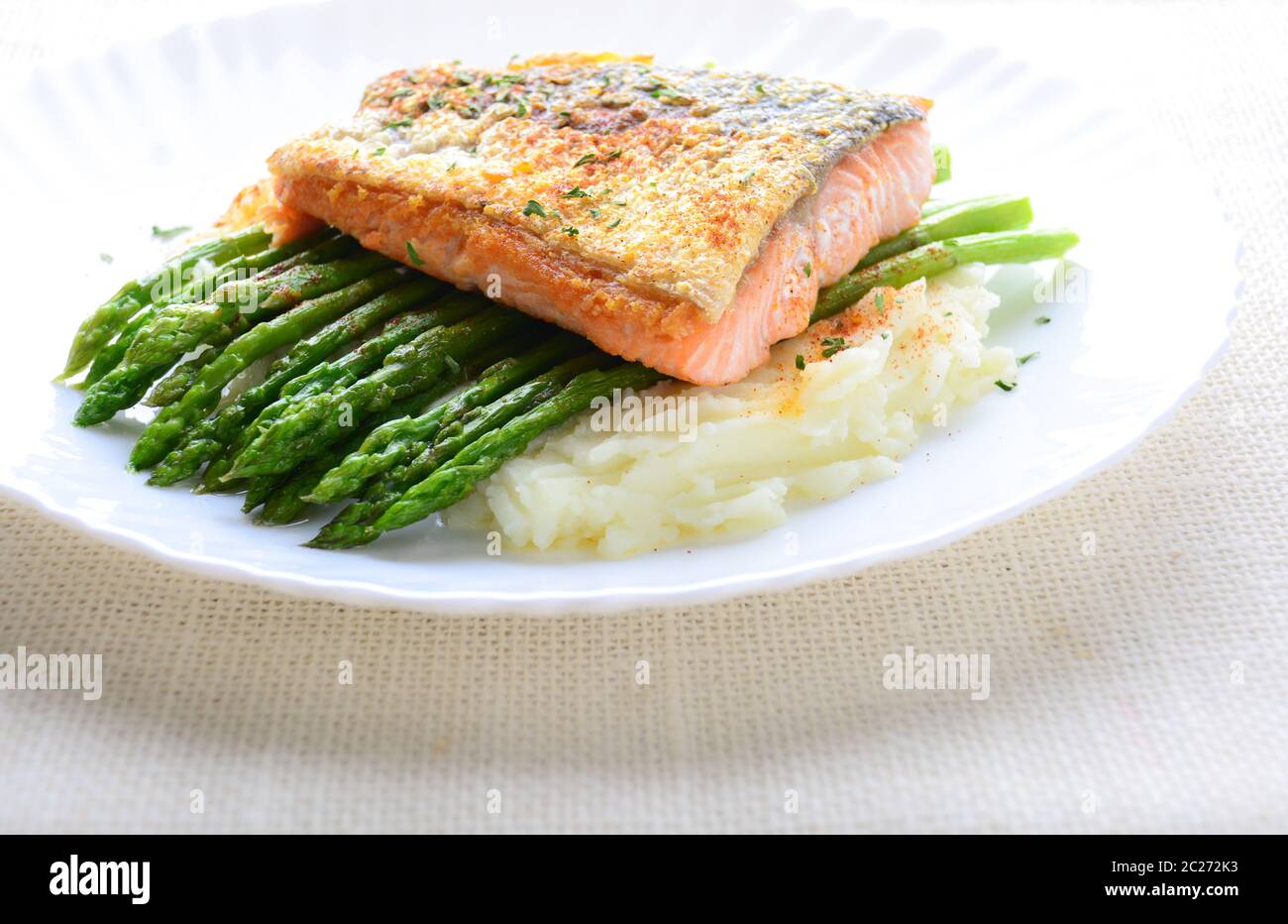 Grilled salmon garnished with asparagus and herbs and mashed potatoes
