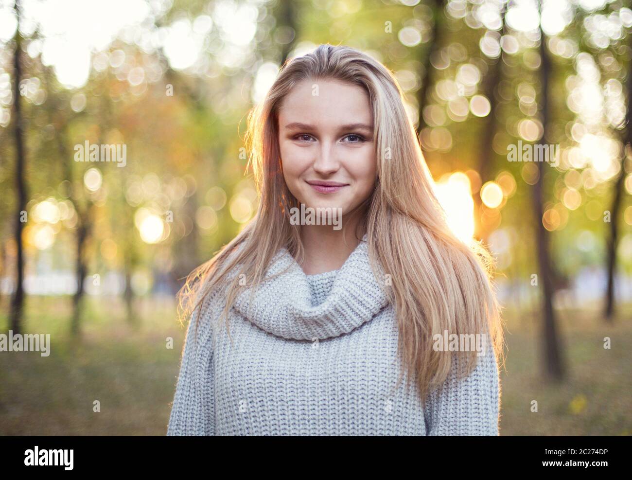 Happy blond girl posing in autumn park Stock Photo - Alamy