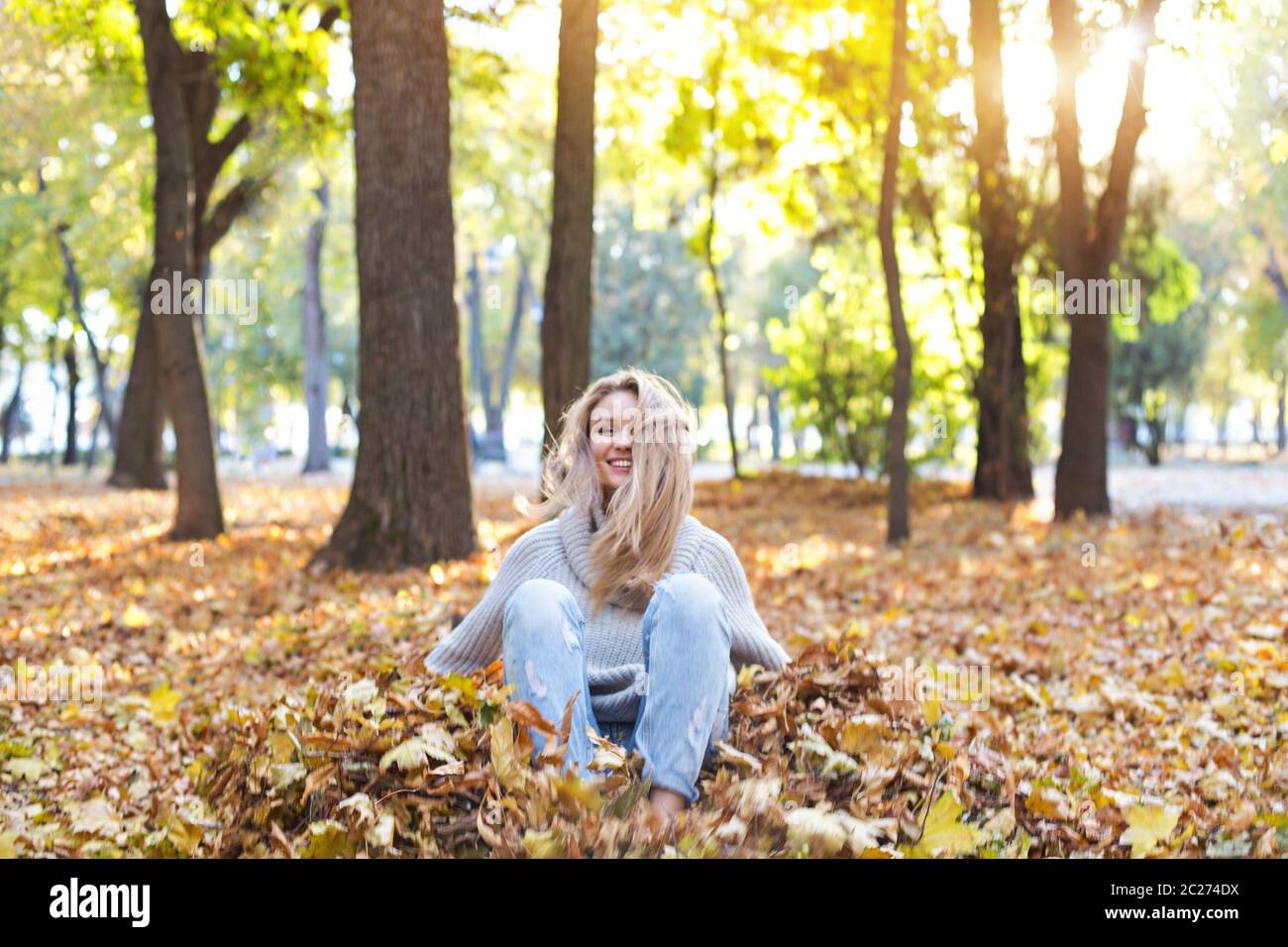 Happy blond girl posing in autumn park on yellow trees background Stock ...