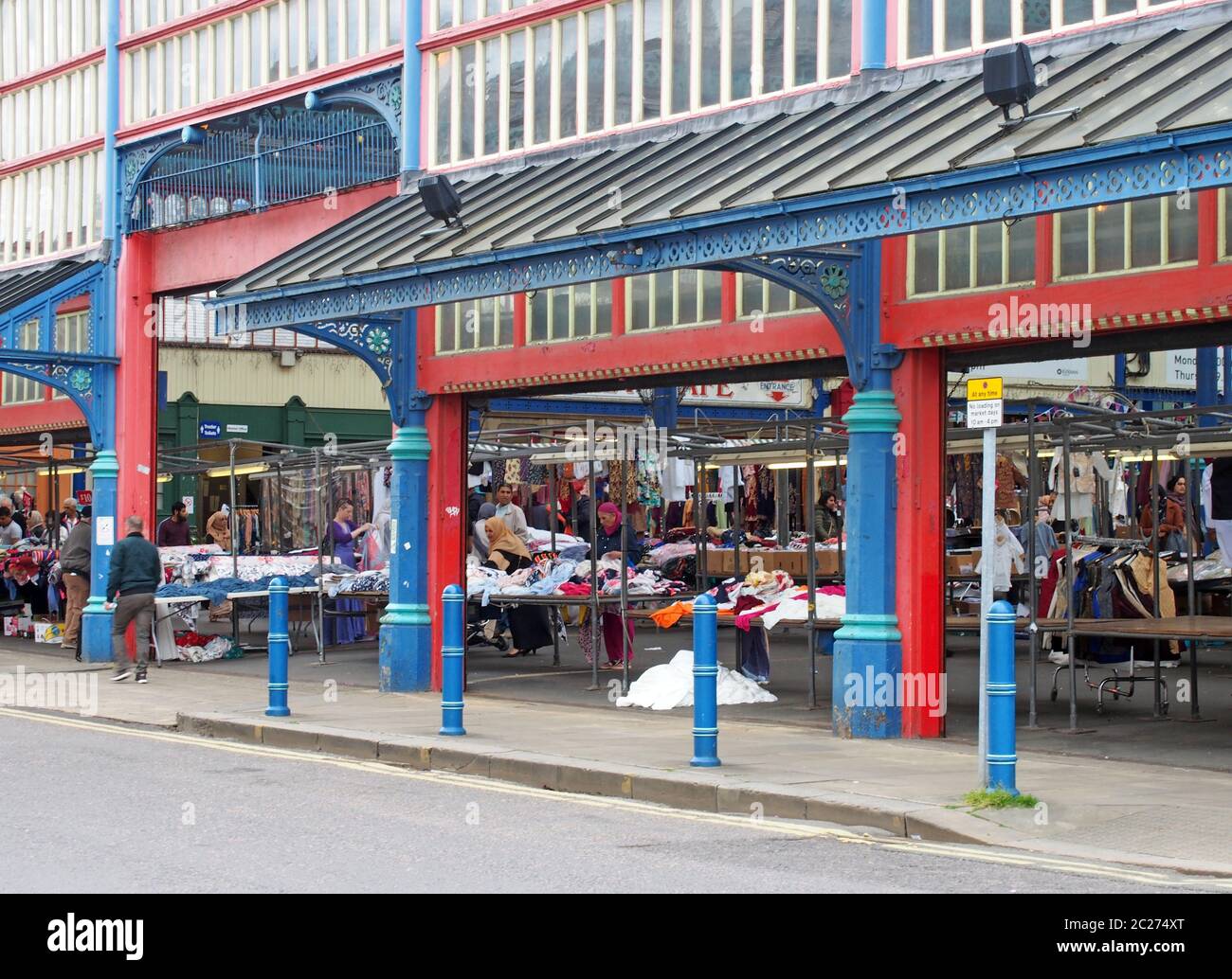 people walking and shopping at stalls in huddersfield market in west yorkshire Stock Photo