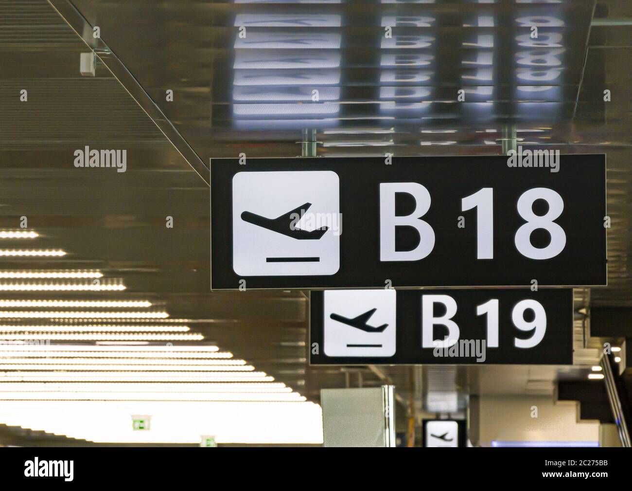 Information panel with the pictogram of an airplane taking off to indicate the boarding gate B 18 in Stock Photo