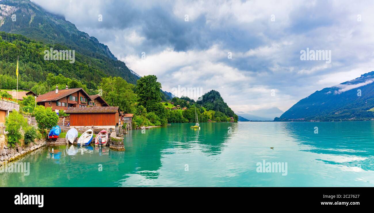 Traditional wood houses, boats and yacht on the Lake Brienz in swiss village Iseltwald