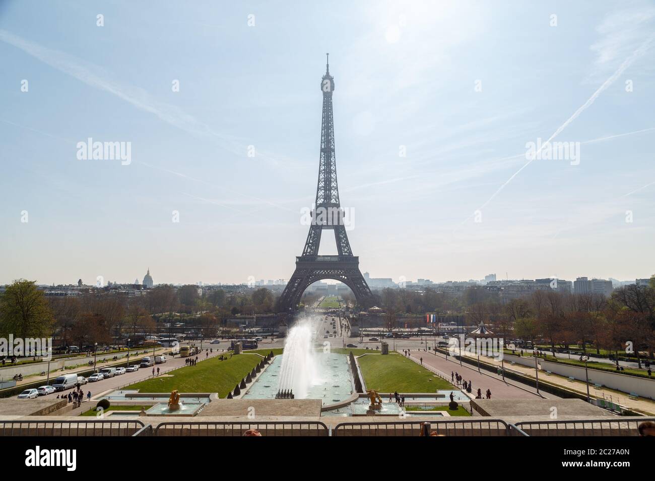 The Eiffel tower in daylight blue sky with some cloud. Champ de Mars park and people in foreground Stock Photo
