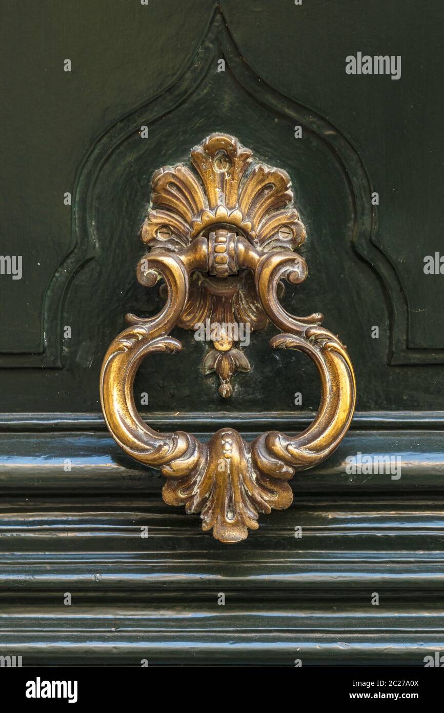 Detail of a bronze metal knocker on a wooden door of house Stock Photo ...