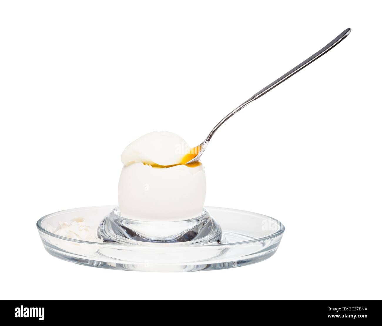 side view of softboiled white egg with spoon in glass egg cup isolated on white background
