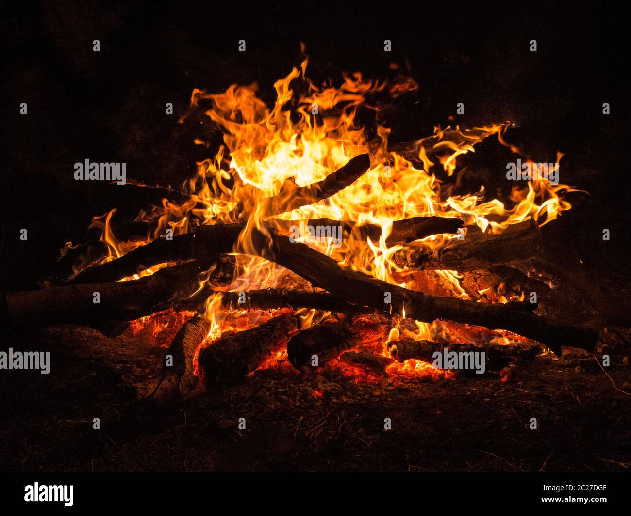 Hot campfire place full of crackling fire wood. Stock Photo