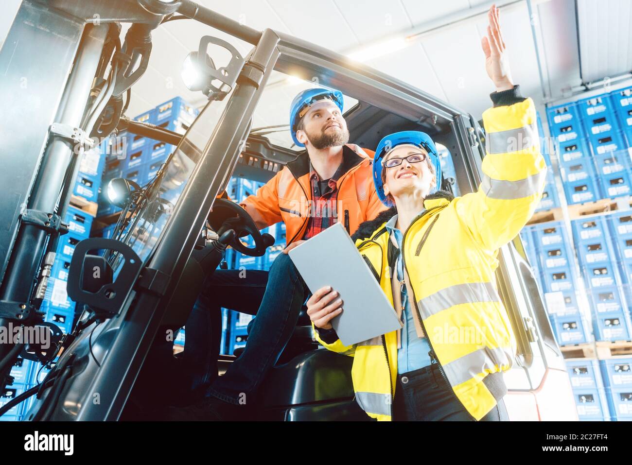 Workers in logistics warehouse checking the inventory with data being supplied by an erp system Stock Photo