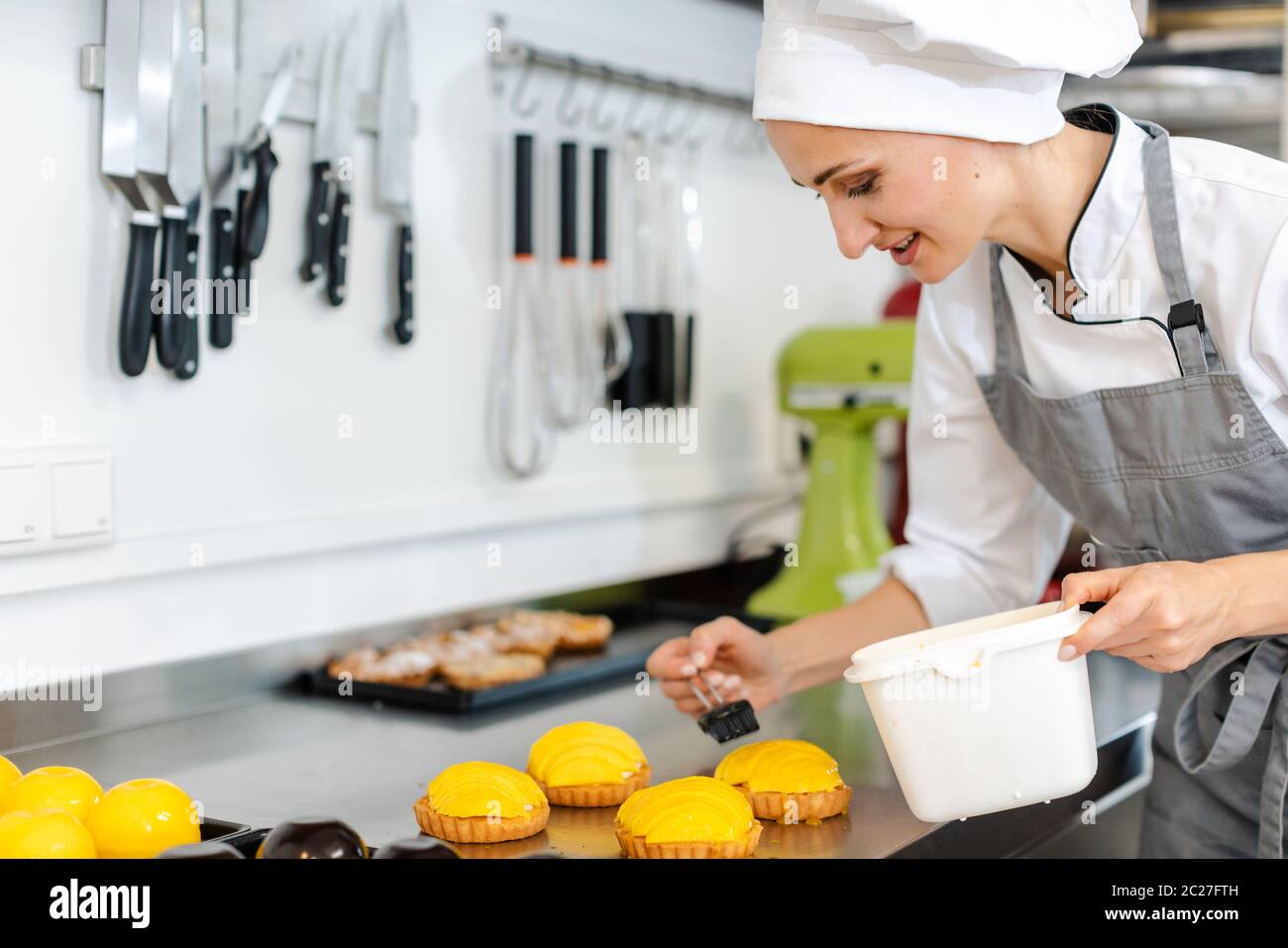 Absorbed confectioner working on sweet little cakes Stock Photo
