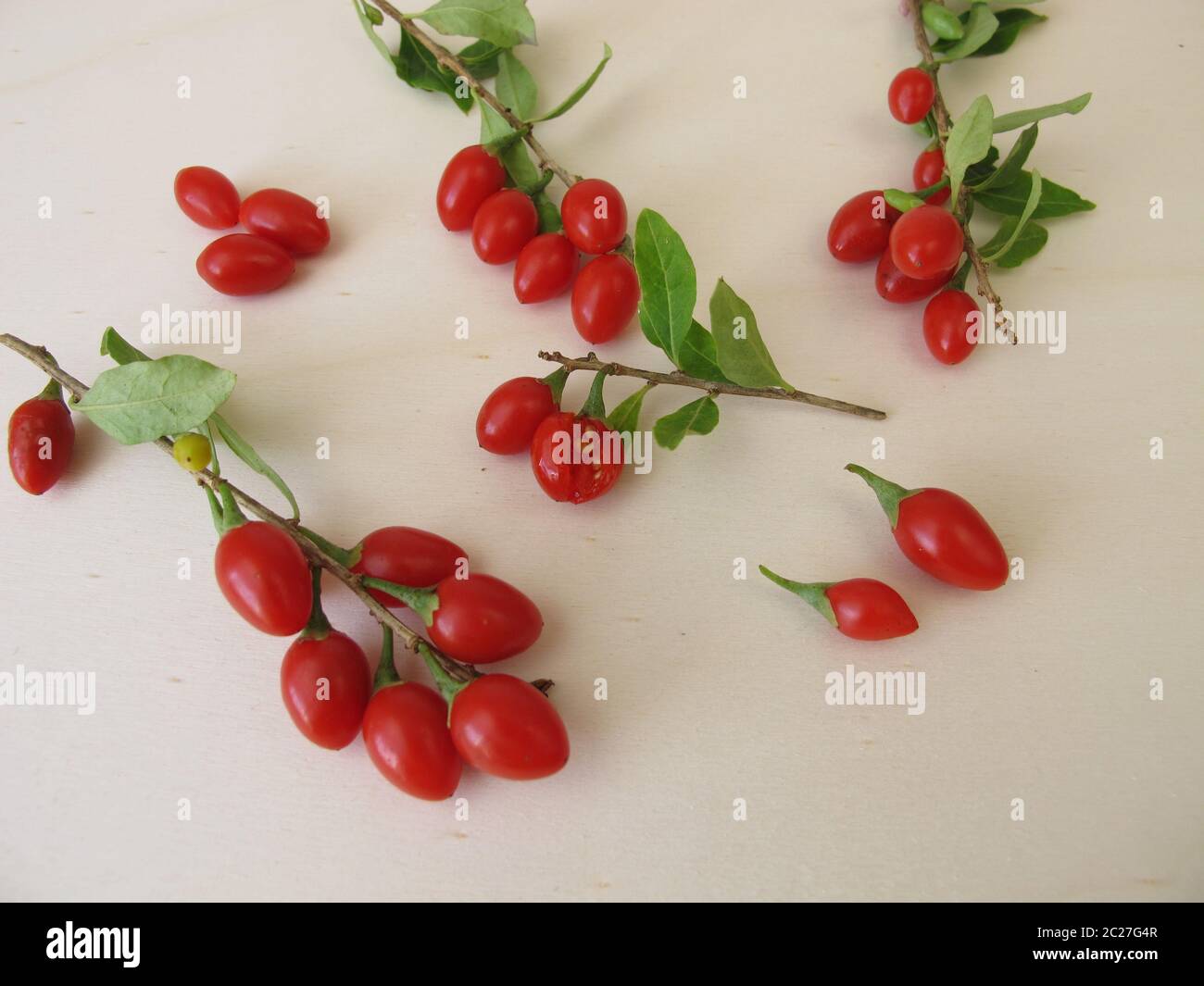 Freshly harvested goji berries, wolfberry on wooden board Stock Photo