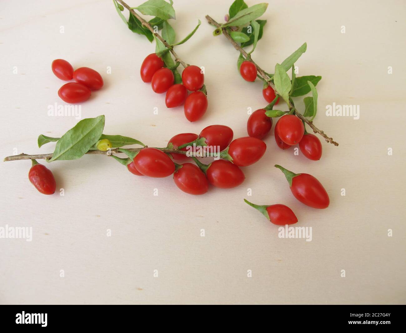 Freshly harvested goji berries, wolfberry on wooden board Stock Photo