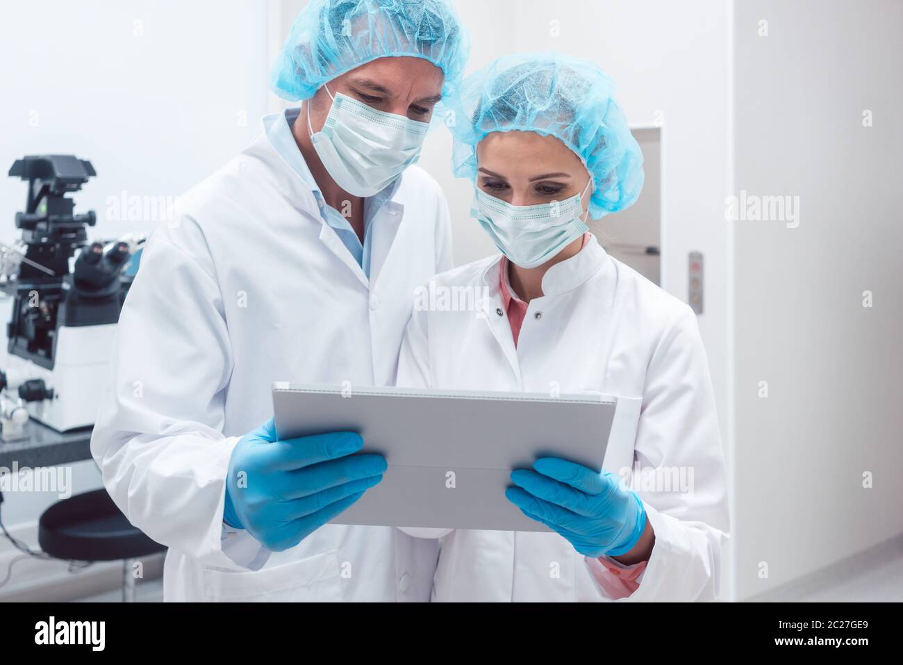 Two scientists working together in lab looking at data on a tablet computer Stock Photo
