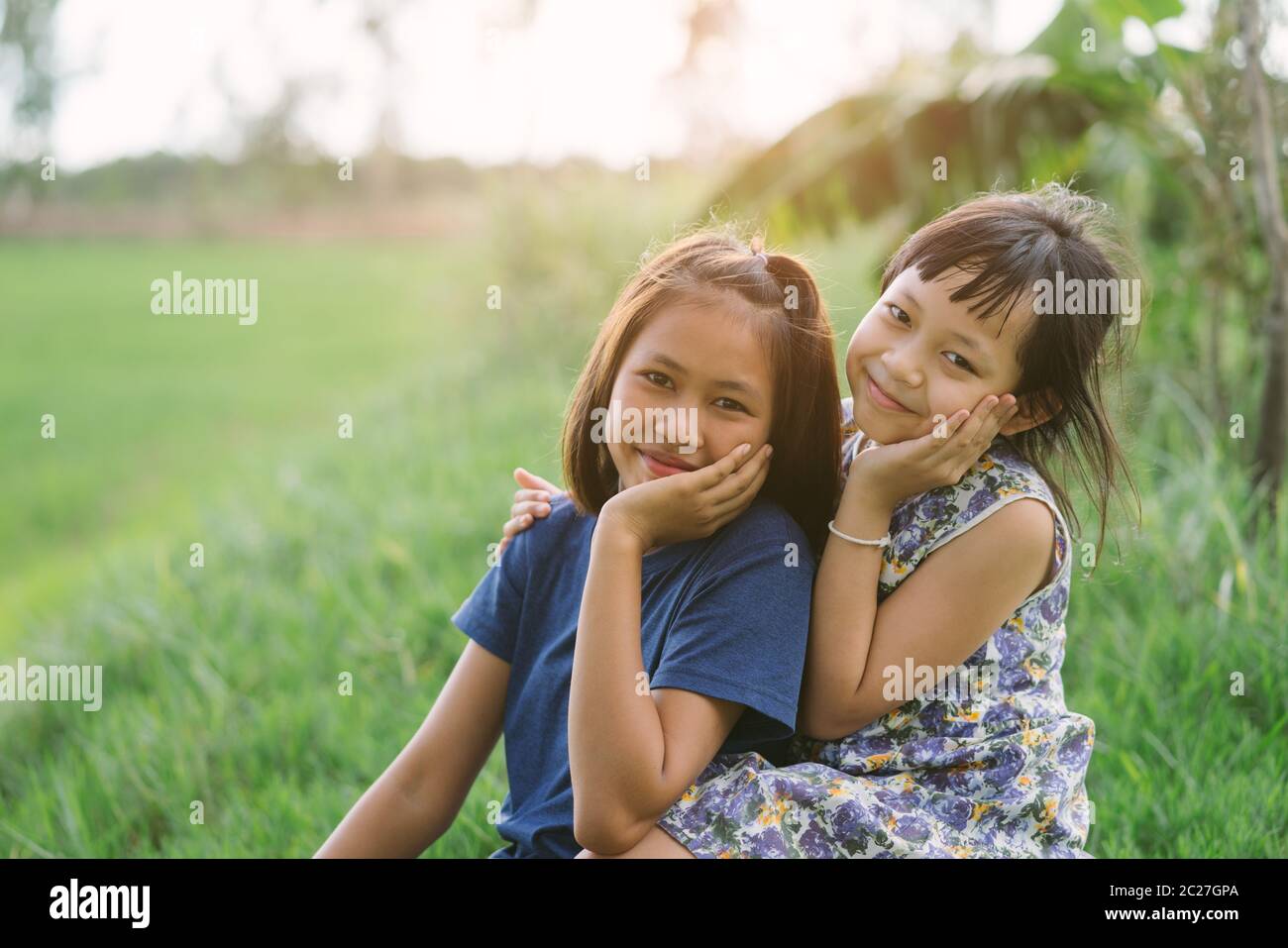 Happy little child girlfriends in green  field Stock Photo