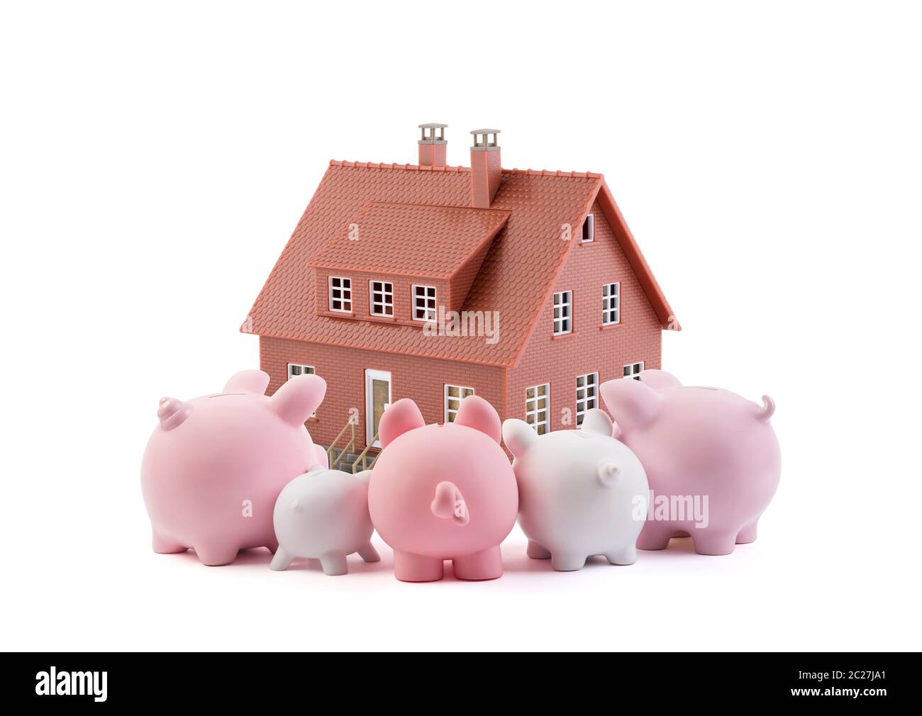 Group of piggy banks looking at the brown house Stock Photo