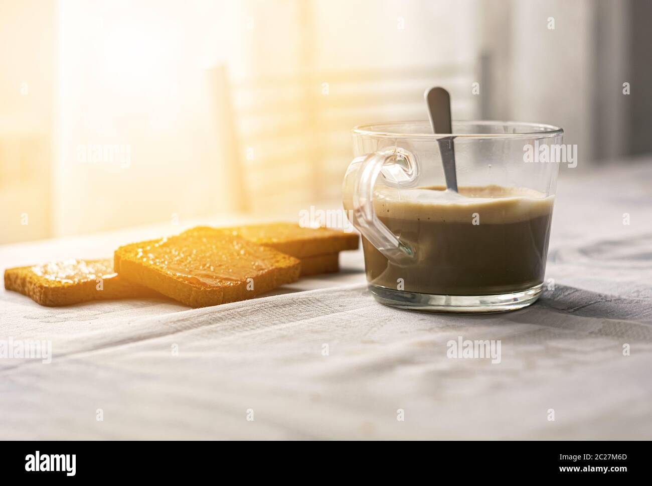 group of biscuits with jam spread with a cup of cappuccino on a table with the decorated tablecloth Stock Photo