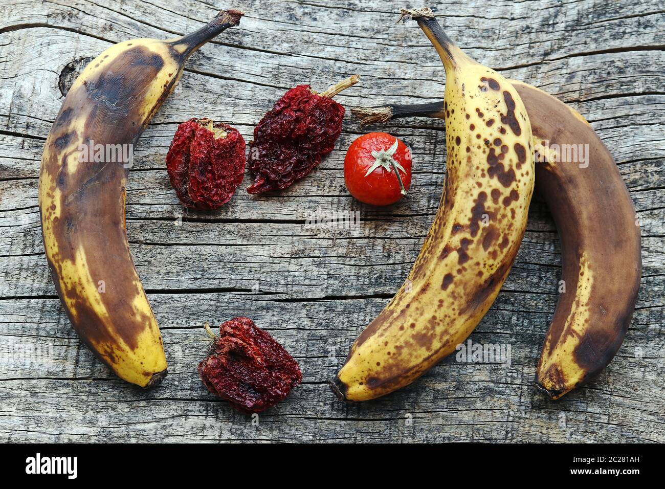 Old brown bananas and dried peppers and tomatoes. Old fruit and vegetables Stock Photo