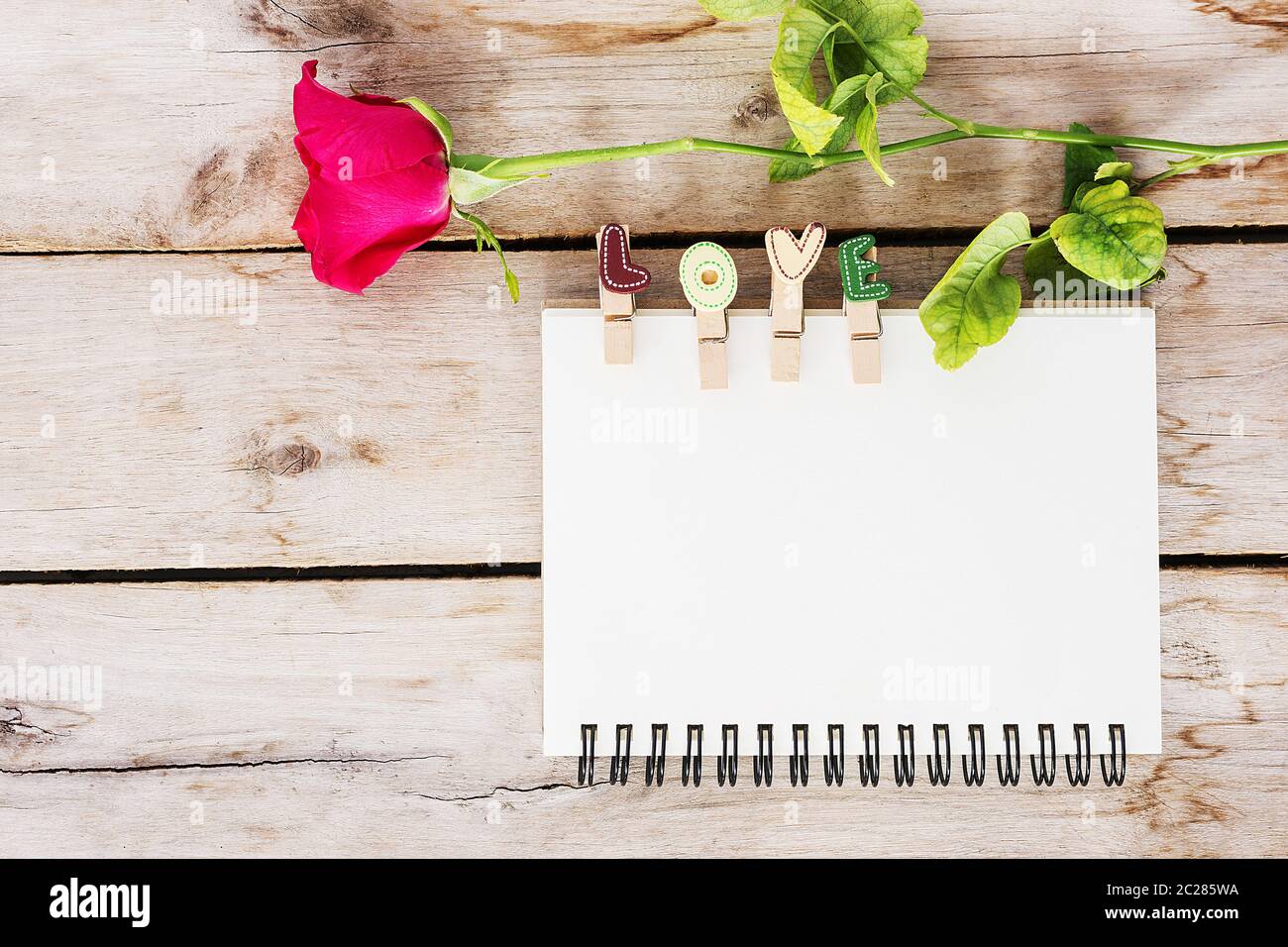 Red rose flower, vintage book and love text on the wooden, valentine's day for background Stock Photo