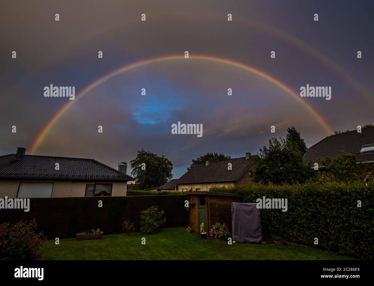 Rainbow over several houses in the Eifel Stock Photo