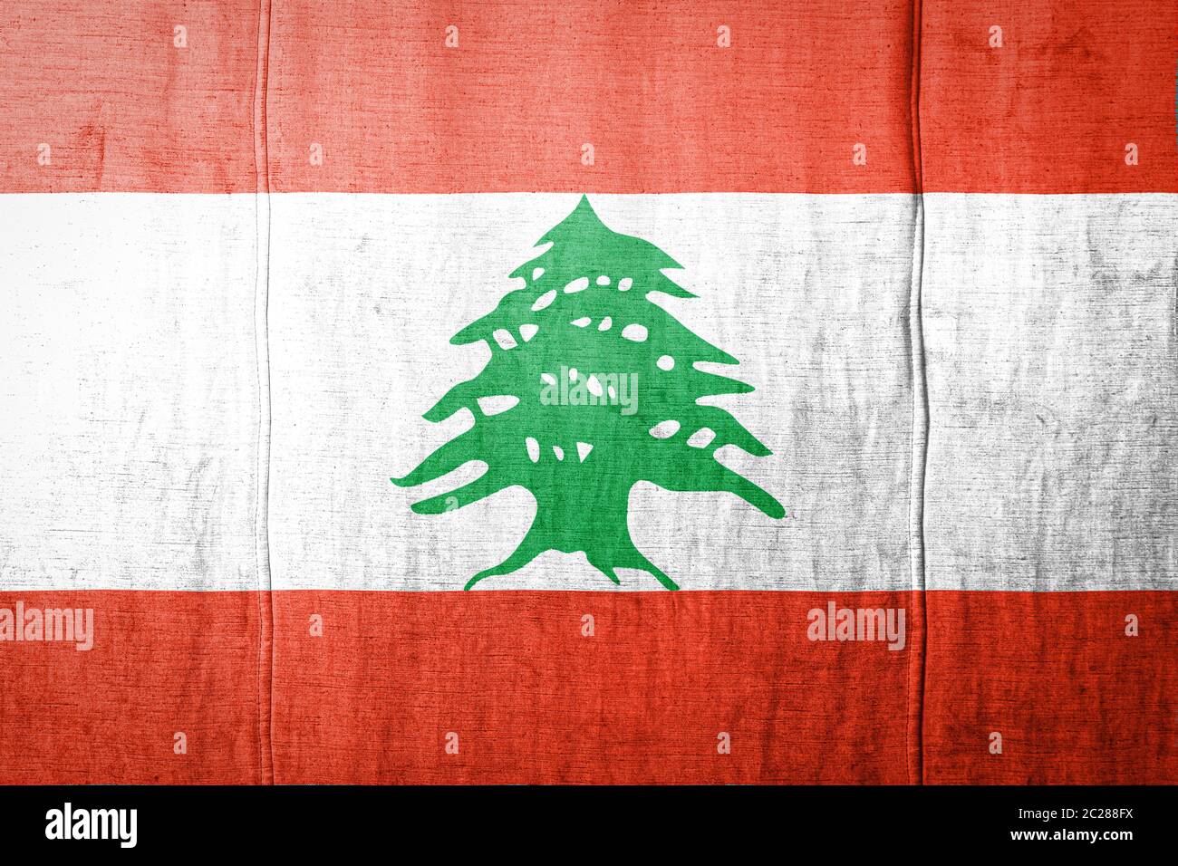 National flag of Lebanon depicting in paint colors on old clothl. Flag banner on fabric texture