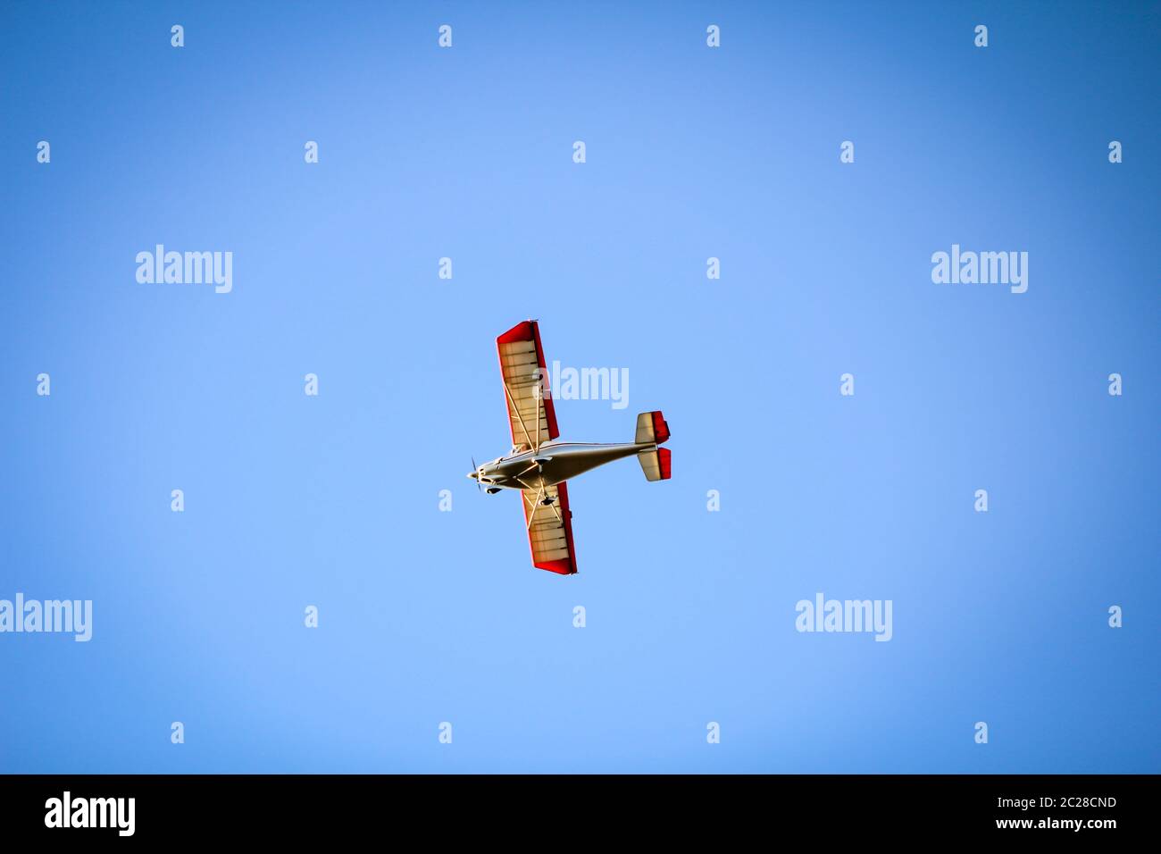 a small airplane in the blue sky Stock Photo