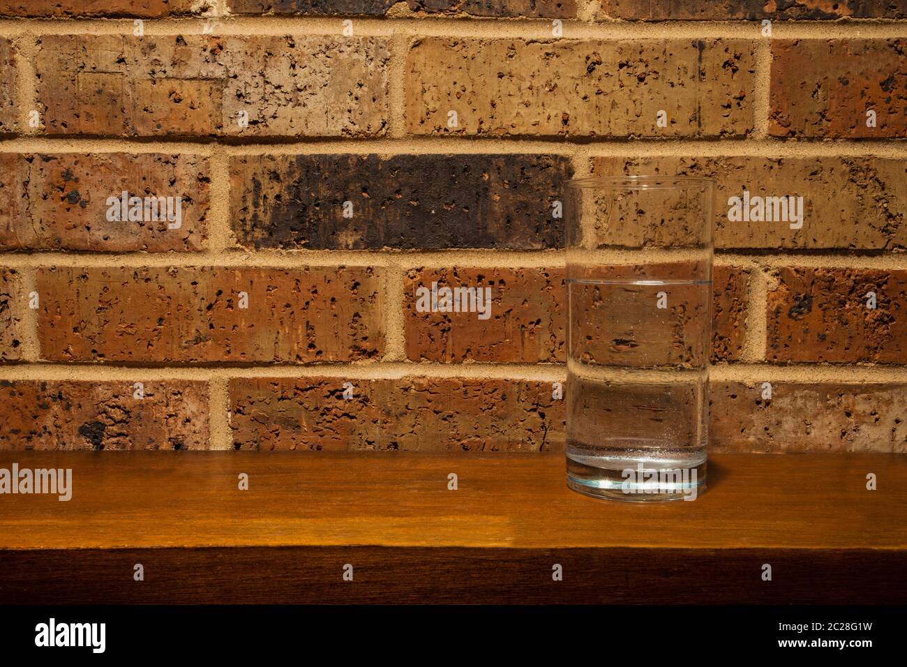 Glass of water on a fireplace mantle Stock Photo
