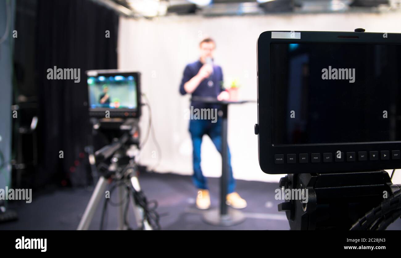 Journalist in a television studio is talking into a microphone, blurry