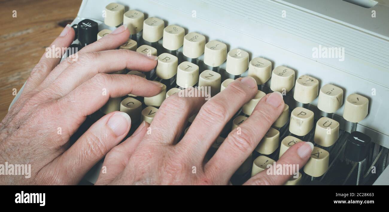 Man is typing on a vintage typewriter Stock Photo