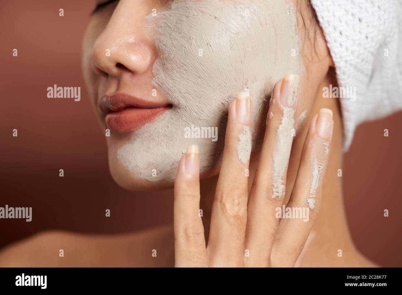 Young woman wearing clay mask on her face Stock Photo - Alamy