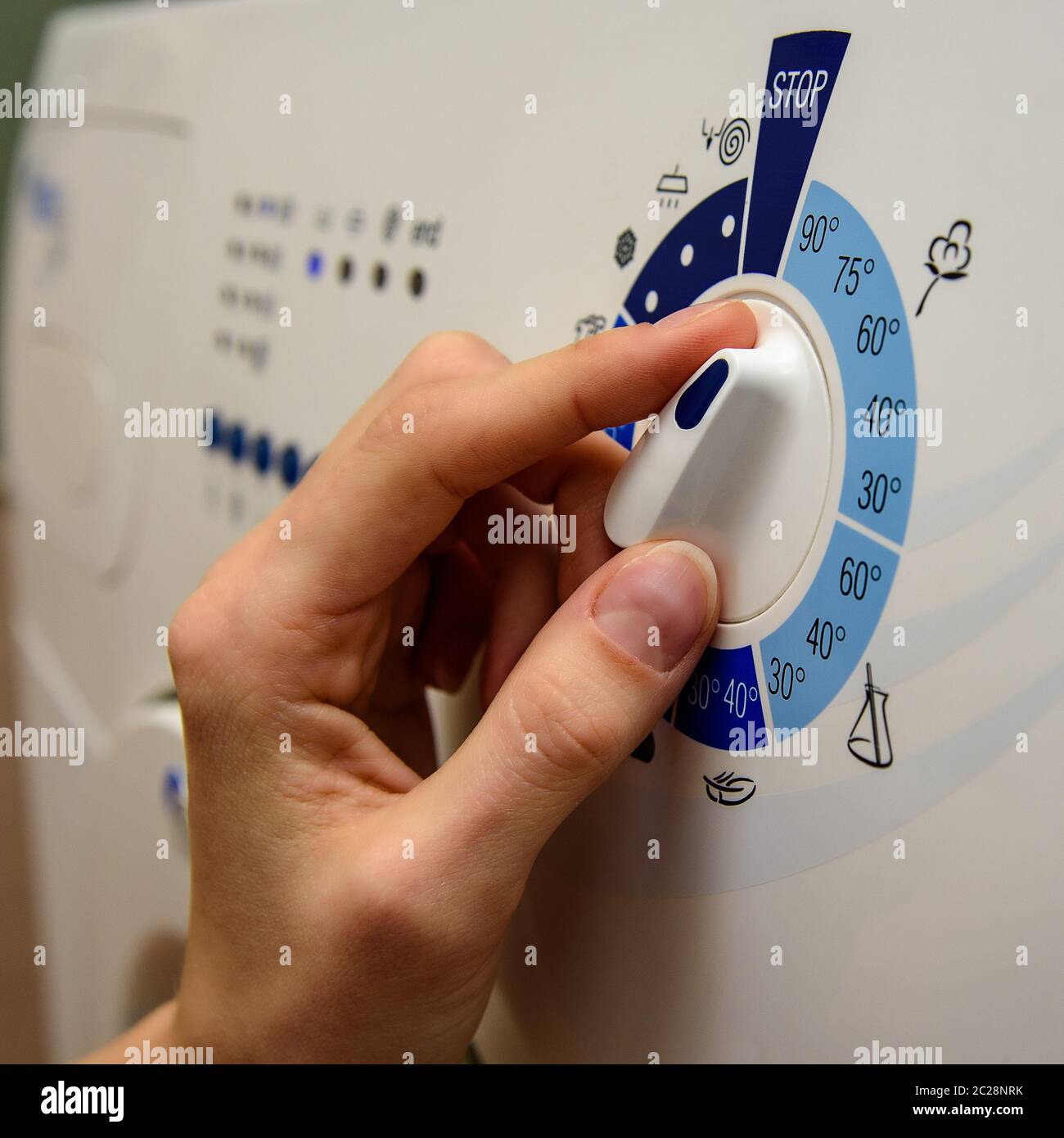 female hand on the handle of the washing machine mode selection Stock
