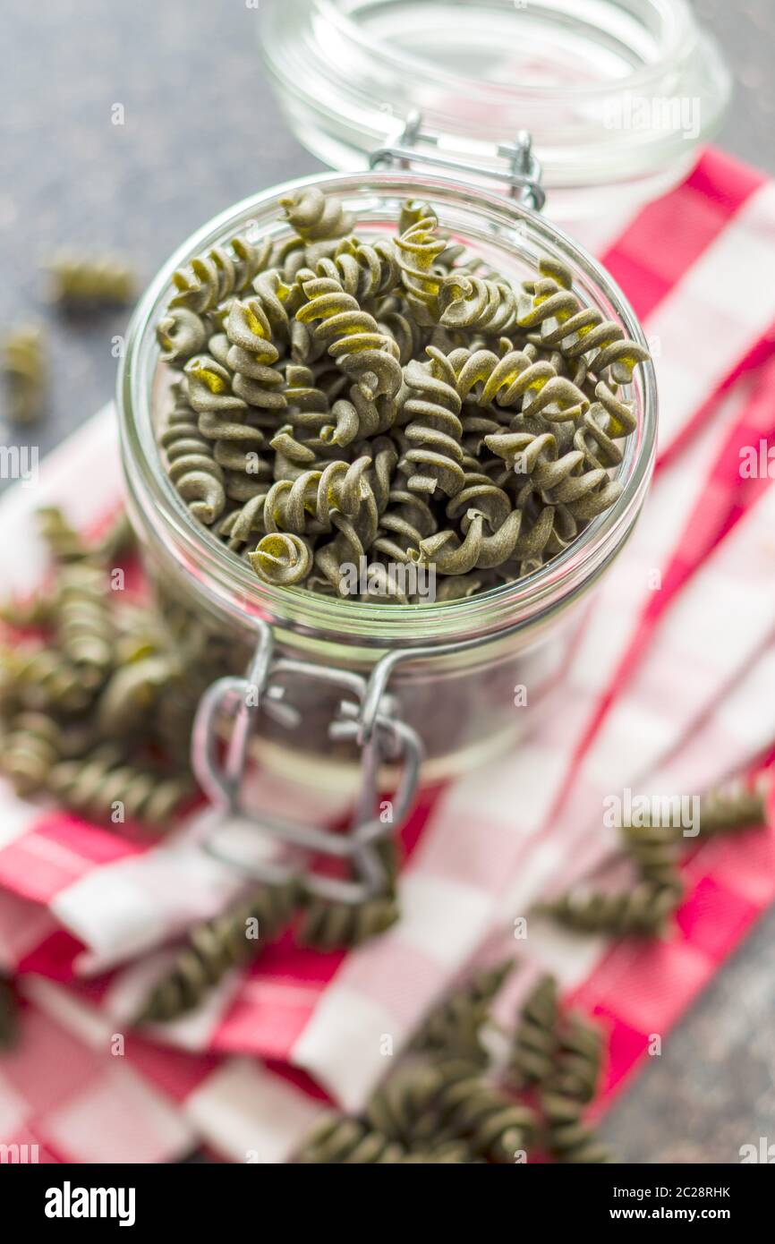 Uncooked colorful pasta with spinach flavor in jar. Stock Photo