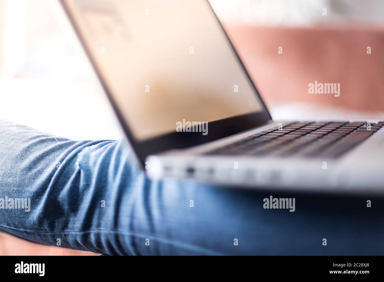 Girl is using a laptop at home on the couch, leisure Stock Photo - Alamy