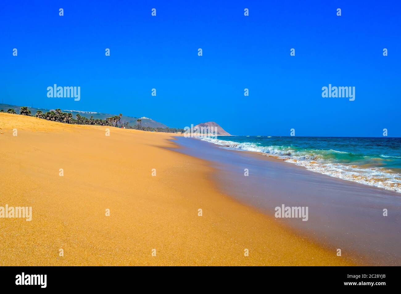 Wild empty tropical beach, yellow sand and blue sky Stock Photo