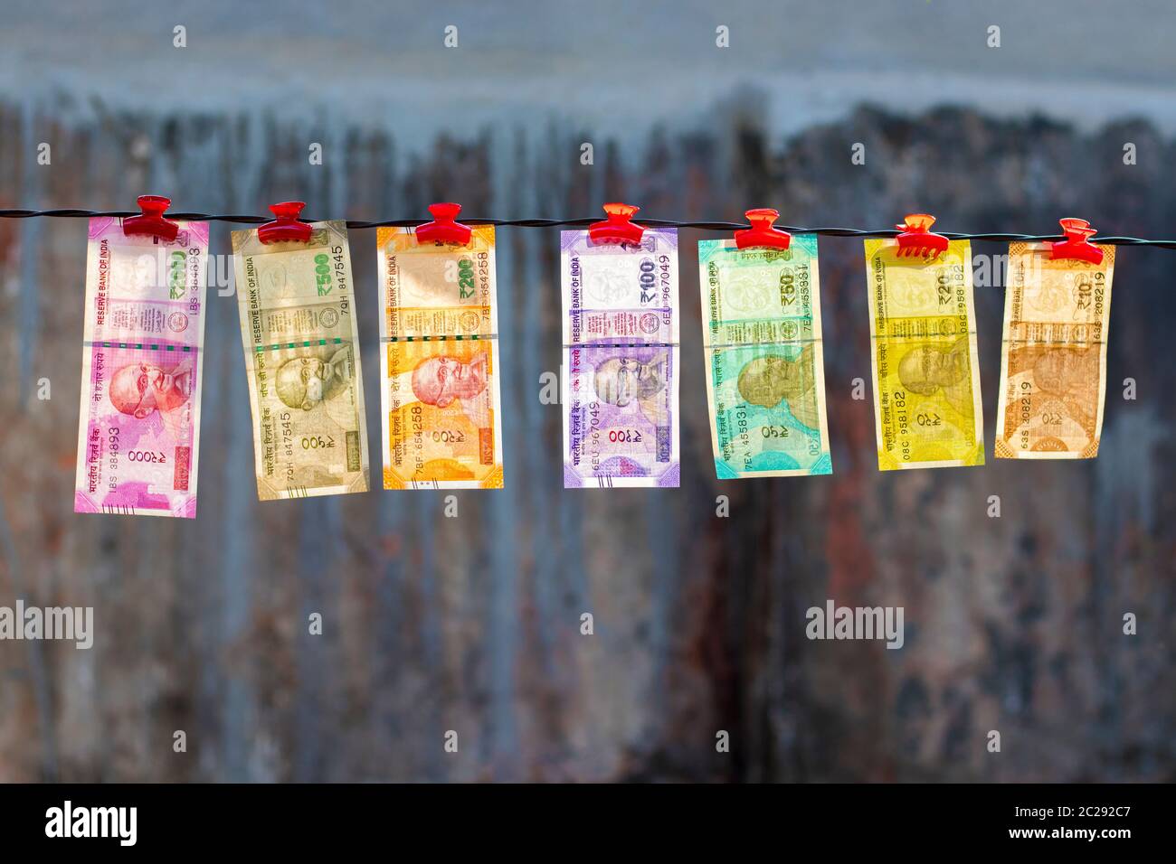 selective focus of new Indian currency notes rupees ten,twenty,fifty hundred,two hundred,five hundred and two thousand hanging in a wire. Stock Photo
