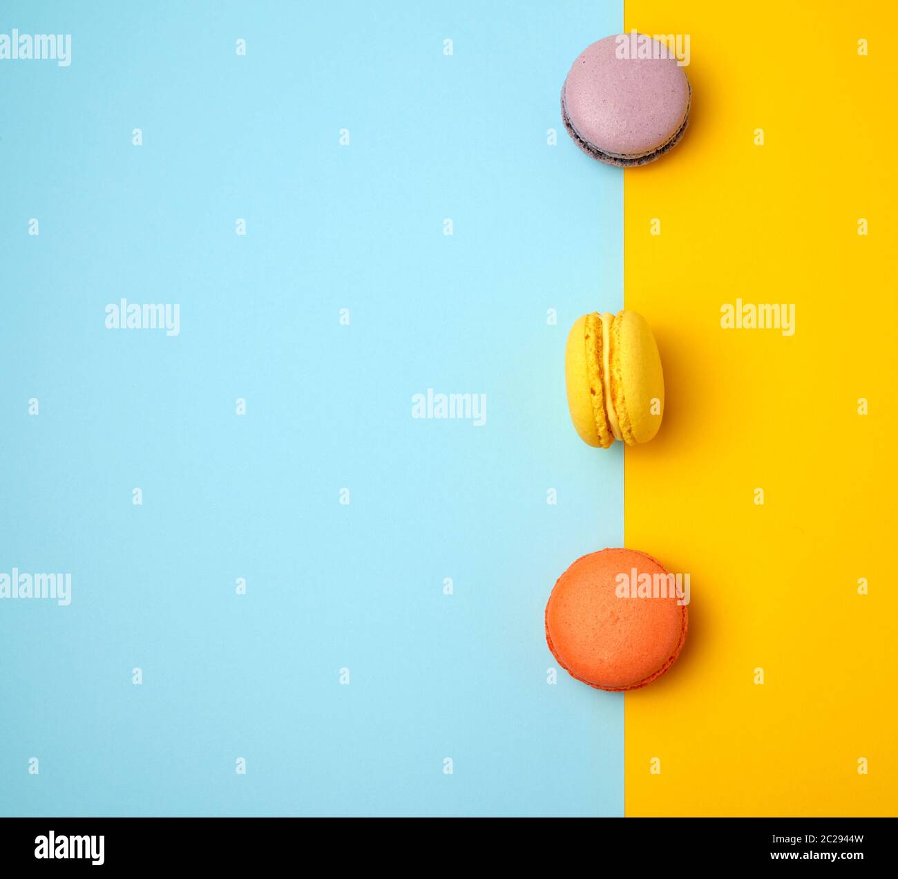 multi-colored baked round macarons on a colored background, flat lay Stock Photo