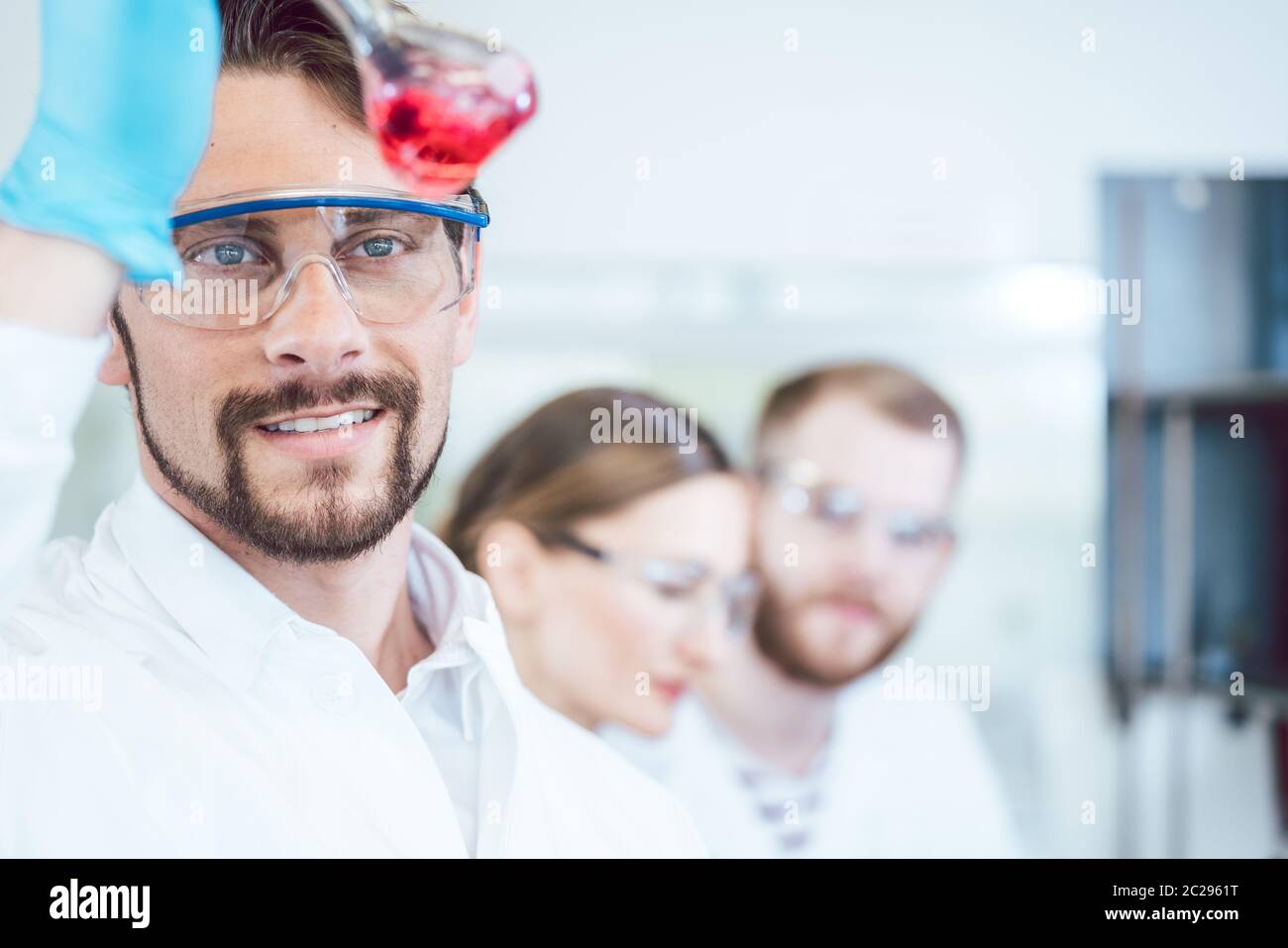 Analytical Chemist Analyzing A Red Solution That Looks Promising Stock 