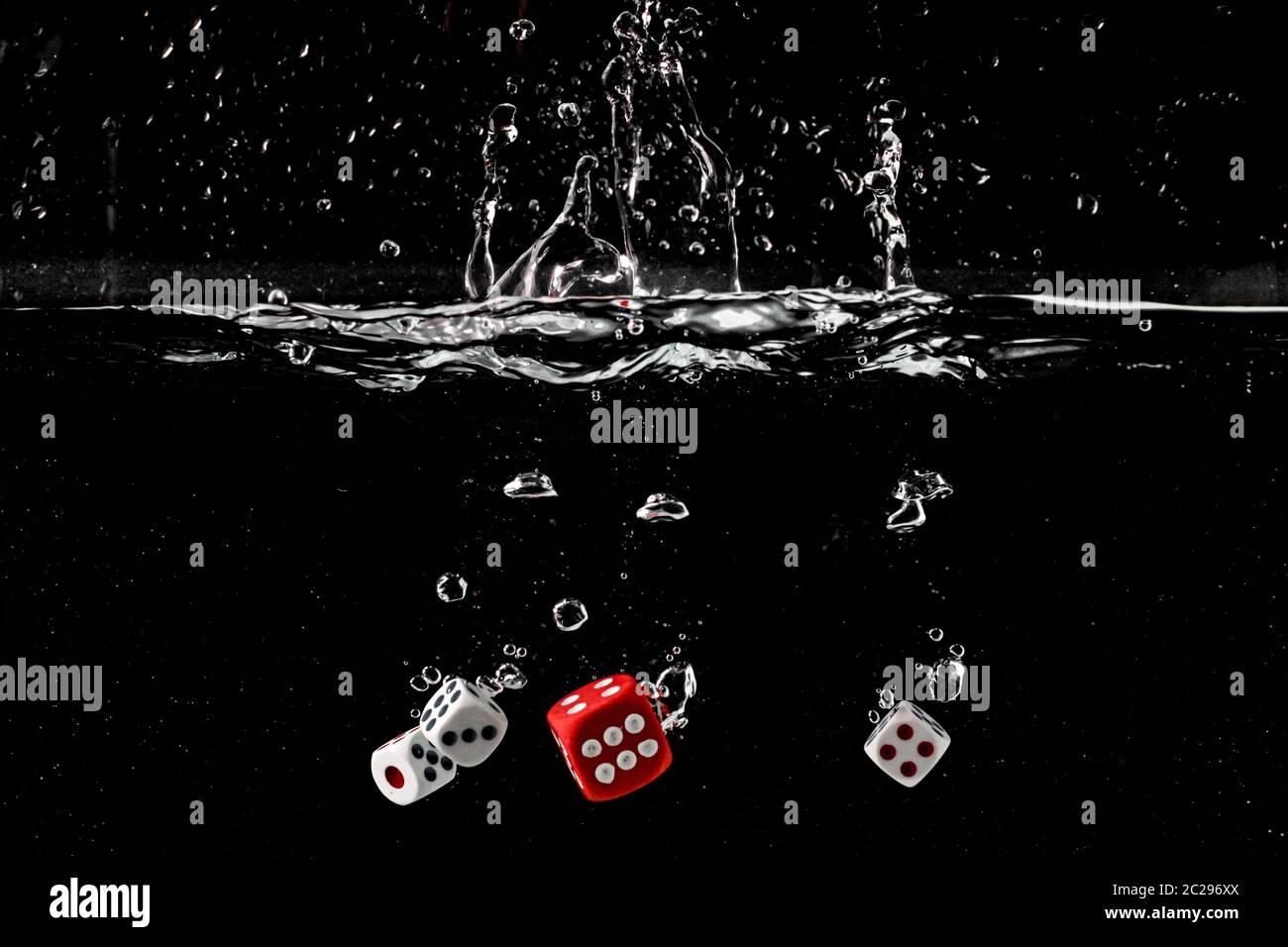Ludo dice in water splash on black background with lots of air bubbles Stock Photo
