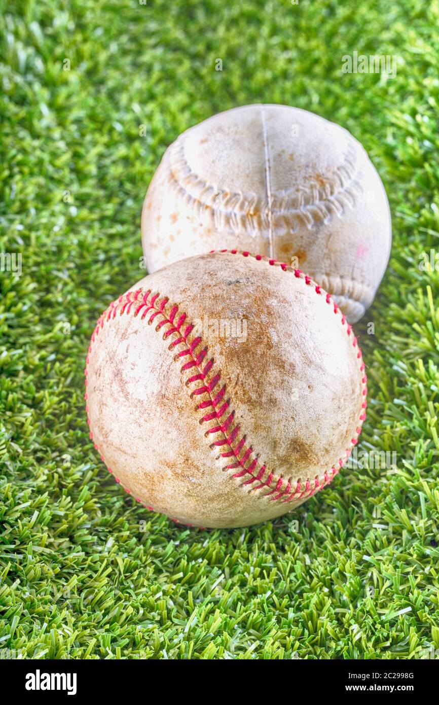 Old baseballs over synthetic grass, vertical HDR image Stock Photo