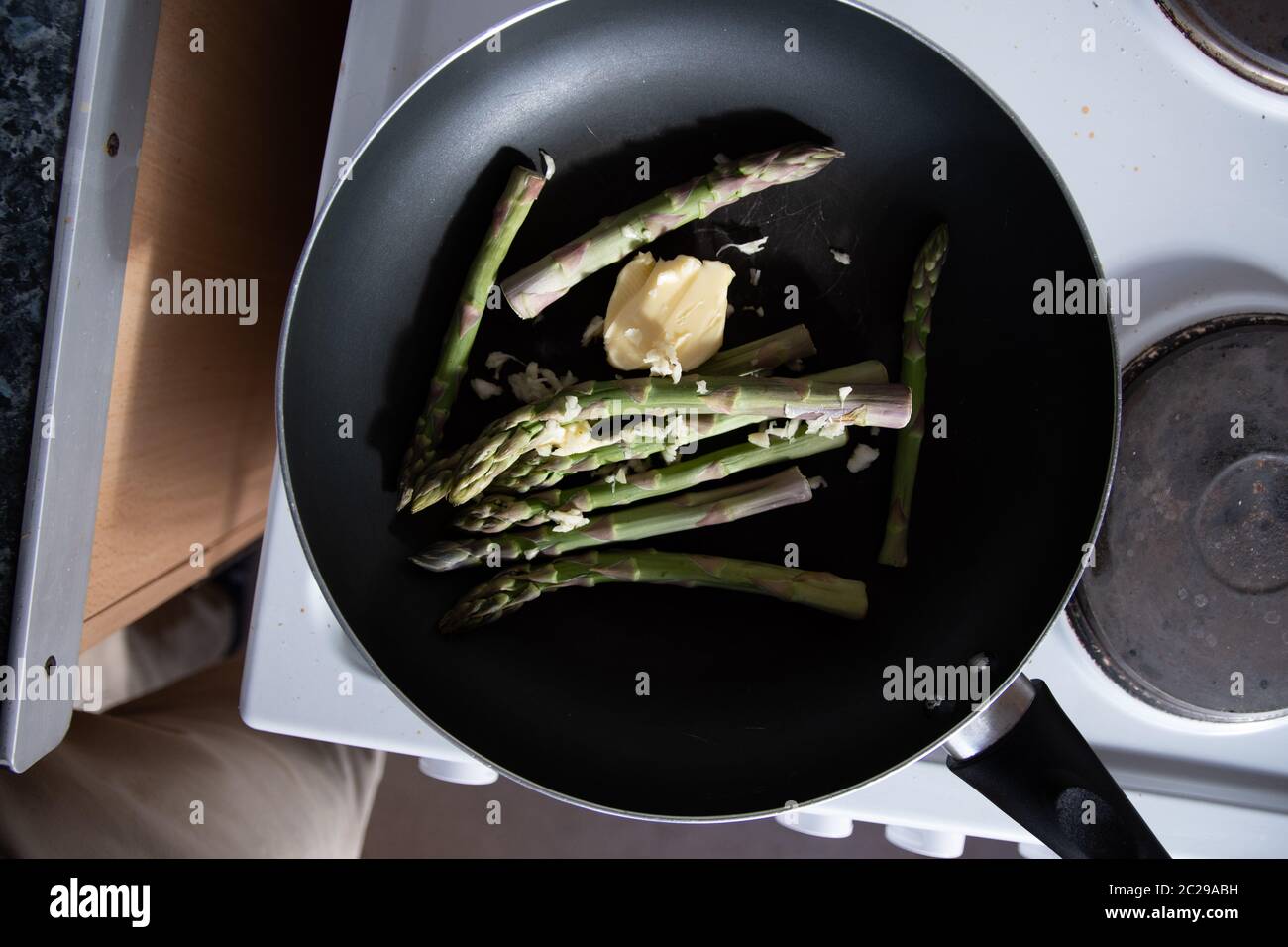 Some fresh green asparagus cooking and frying in a pan on the ho Stock Photo